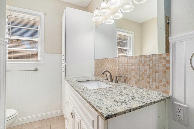 bathroom with tasteful backsplash, vanity, toilet, and tile patterned flooring