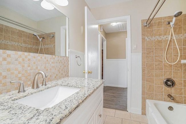 bathroom featuring vanity, tiled shower / bath combo, and tile patterned flooring