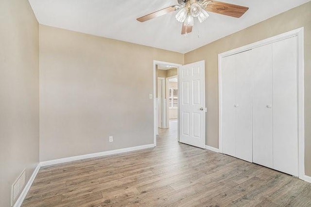 unfurnished bedroom with ceiling fan, light wood-type flooring, and a closet