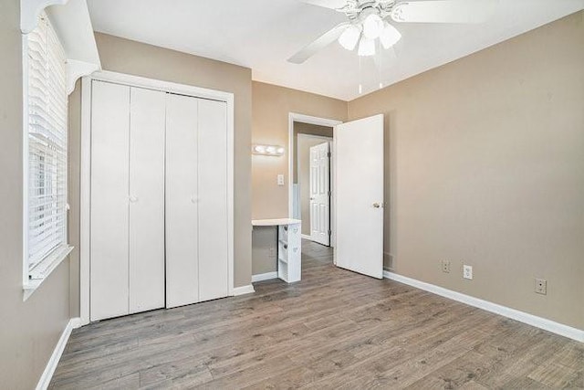 unfurnished bedroom with a closet, ceiling fan, and light wood-type flooring