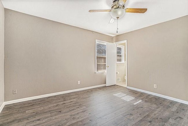 spare room with ceiling fan and dark hardwood / wood-style floors