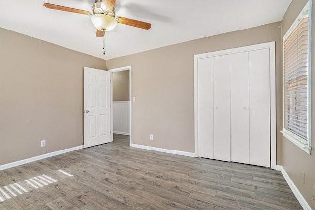 unfurnished bedroom with hardwood / wood-style flooring, ceiling fan, and a closet