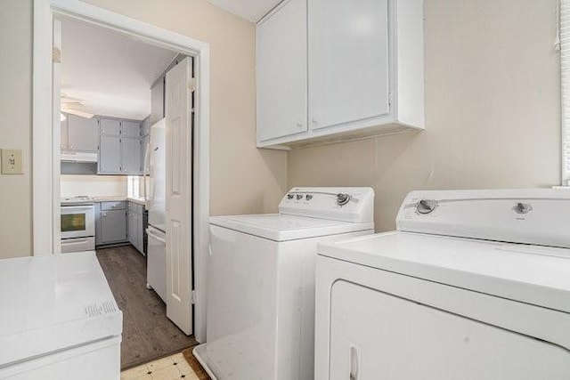 clothes washing area featuring cabinets, separate washer and dryer, and light hardwood / wood-style floors