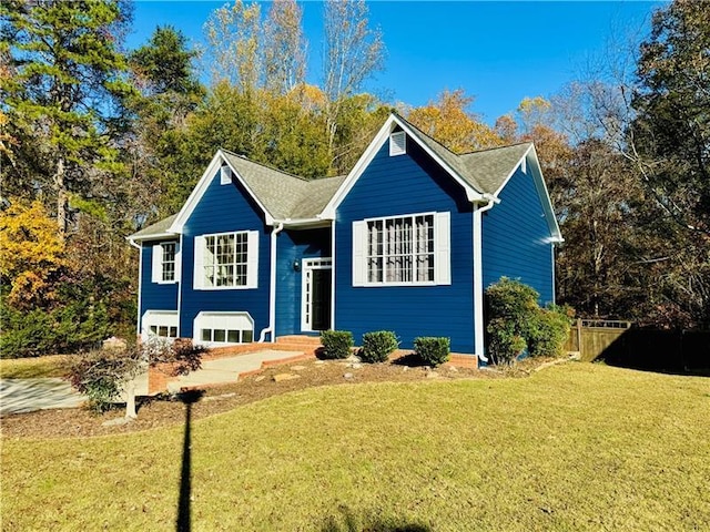 bi-level home featuring a front yard and fence