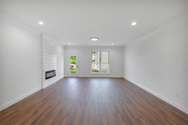 unfurnished living room featuring heating unit, crown molding, and dark wood-type flooring