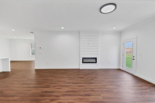 unfurnished living room with dark hardwood / wood-style floors, crown molding, and a fireplace