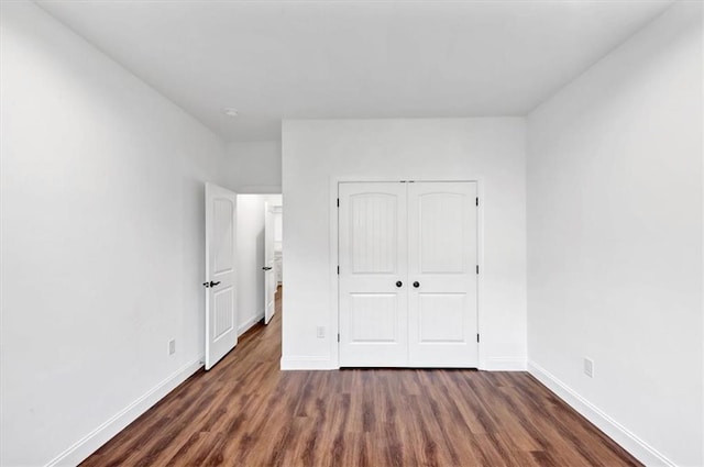 unfurnished bedroom featuring dark wood-type flooring and a closet