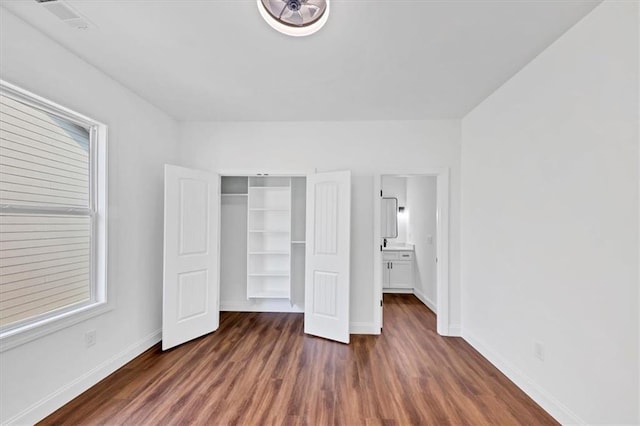 unfurnished bedroom featuring a closet and dark wood-type flooring