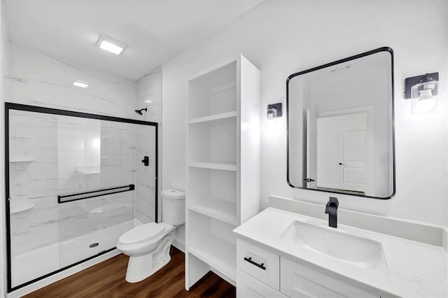 bathroom with vanity, walk in shower, hardwood / wood-style floors, and toilet