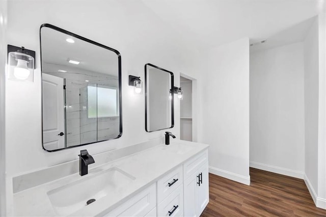 bathroom featuring wood-type flooring, an enclosed shower, and vanity