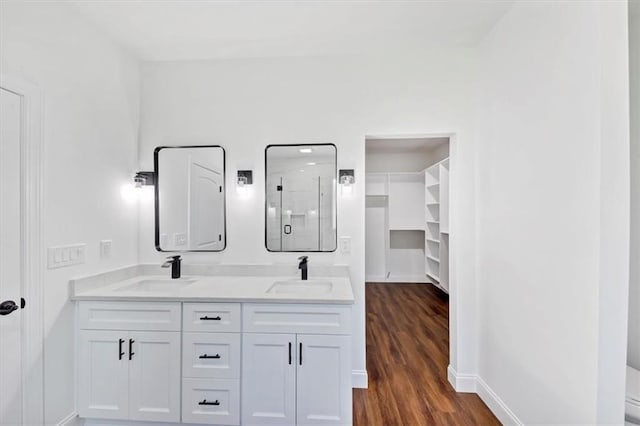 bathroom with a shower with door, hardwood / wood-style floors, and vanity