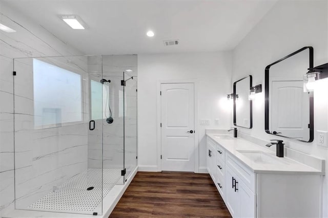 bathroom featuring hardwood / wood-style floors, walk in shower, and vanity