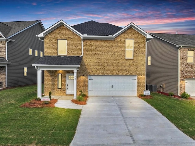 view of front of house with cooling unit, a lawn, and a garage