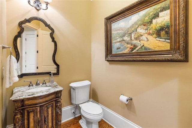 bathroom with vanity, toilet, and wood-type flooring