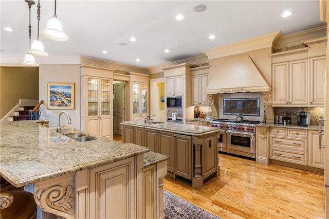 kitchen featuring a spacious island, sink, custom exhaust hood, hanging light fixtures, and appliances with stainless steel finishes