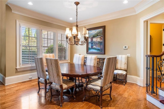 dining room featuring crown molding, an inviting chandelier, and light wood-type flooring