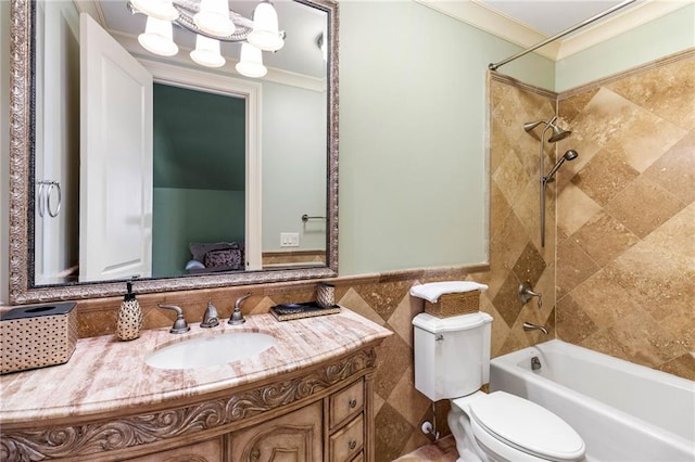 full bathroom featuring toilet, crown molding, tile walls, vanity, and tiled shower / bath combo