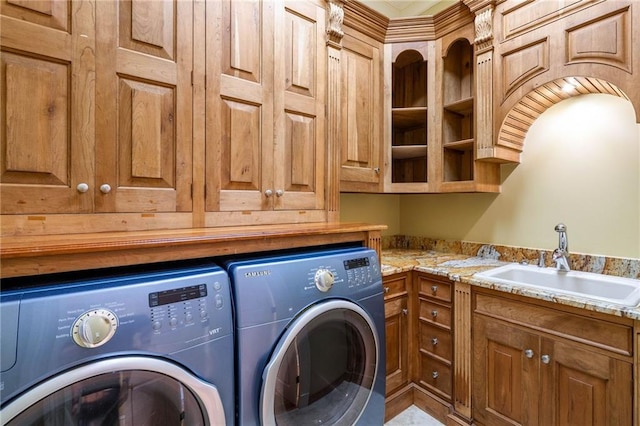 clothes washing area featuring cabinets, sink, and independent washer and dryer