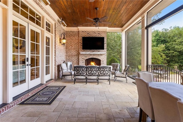 view of patio / terrace with an outdoor brick fireplace, ceiling fan, and french doors