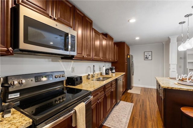 1360 Mount Mickinley Dr, Grayson, GA 30017 - kitchen featuring appliances with stainless steel finishes, dark wood-style floors, light stone countertops, hanging light fixtures, and crown molding