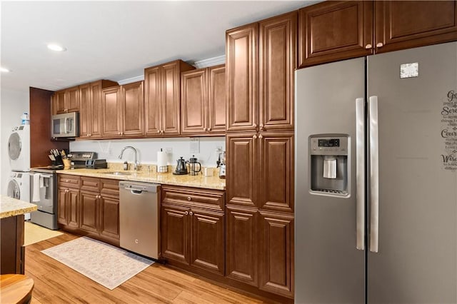 1360 Mount Mickinley Dr, Grayson, GA 30017 - kitchen with appliances with stainless steel finishes, stacked washing machine and dryer, light wood-type flooring, recessed lighting, and light stone counters