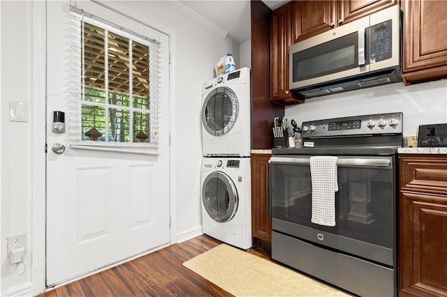 1360 Mount Mickinley Dr, Grayson, GA 30017 - laundry room with stacked washer / dryer, crown molding, and dark wood-style flooring