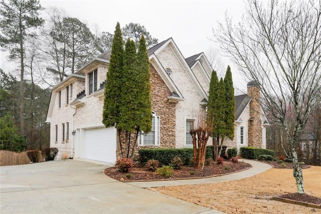 1360 Mount Mickinley Dr, Grayson, GA 30017 - view of front of house with stone siding, a garage, concrete driveway, and a chimney