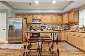 1360 Mount Mickinley Dr, Grayson, GA 30017 - kitchen with appliances with stainless steel finishes, light wood-type flooring, backsplash, light brown cabinetry, and recessed lighting