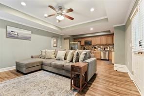 1360 Mount Mickinley Dr, Grayson, GA 30017 - living area featuring wood finished floors, ceiling fan, a tray ceiling, ornamental molding, and recessed lighting