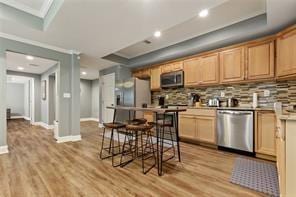 1360 Mount Mickinley Dr, Grayson, GA 30017 - kitchen with appliances with stainless steel finishes, light wood finished floors, decorative backsplash, crown molding, and recessed lighting