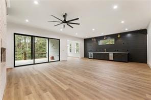 unfurnished living room with wet bar, recessed lighting, and wood finished floors