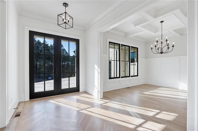 interior space featuring a chandelier, french doors, ornamental molding, and visible vents