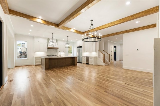 kitchen with open floor plan, light countertops, high quality fridge, and beamed ceiling