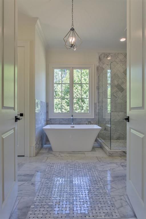 full bathroom with wainscoting, marble finish floor, a freestanding bath, a shower stall, and tile walls