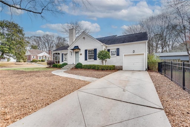 view of front of house featuring a garage, driveway, a chimney, and fence