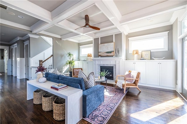 living area with coffered ceiling, stairs, and wood finished floors