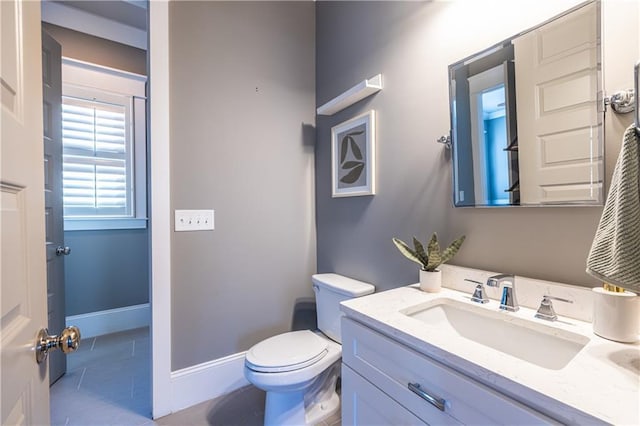 bathroom with tile patterned floors, baseboards, toilet, and vanity