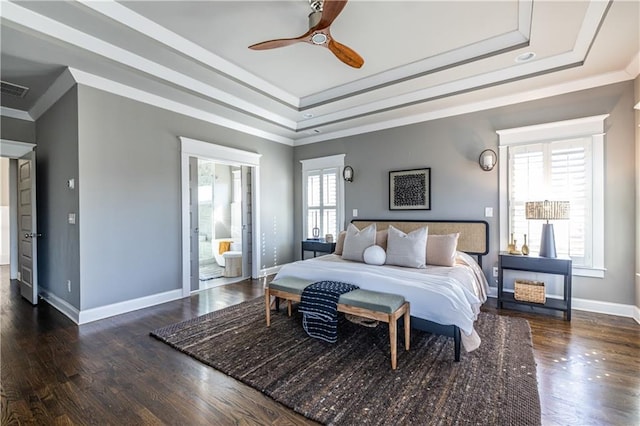 bedroom featuring a tray ceiling, wood finished floors, and ornamental molding