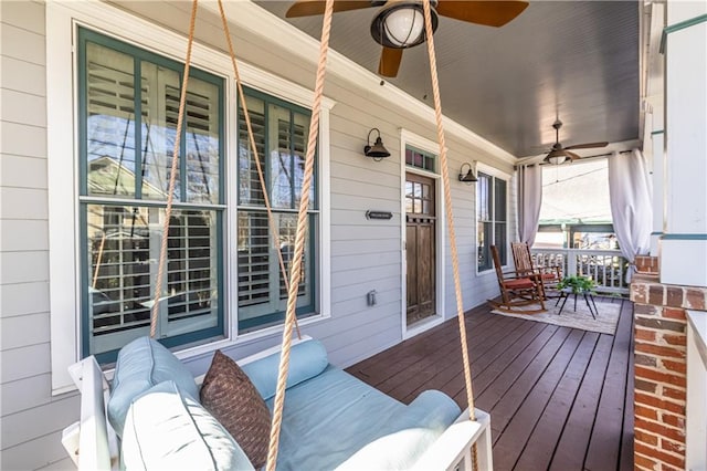 wooden terrace with covered porch and a ceiling fan