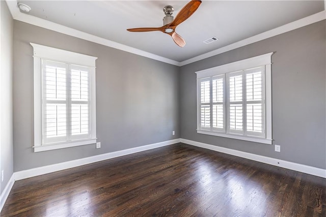 empty room with visible vents, dark wood-type flooring, ceiling fan, baseboards, and ornamental molding