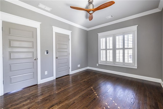 spare room with crown molding, visible vents, and dark wood-style flooring