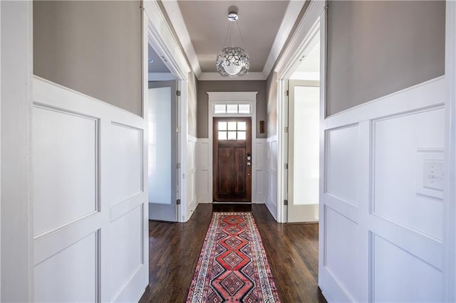 entryway with a wainscoted wall, dark wood-style flooring, and crown molding