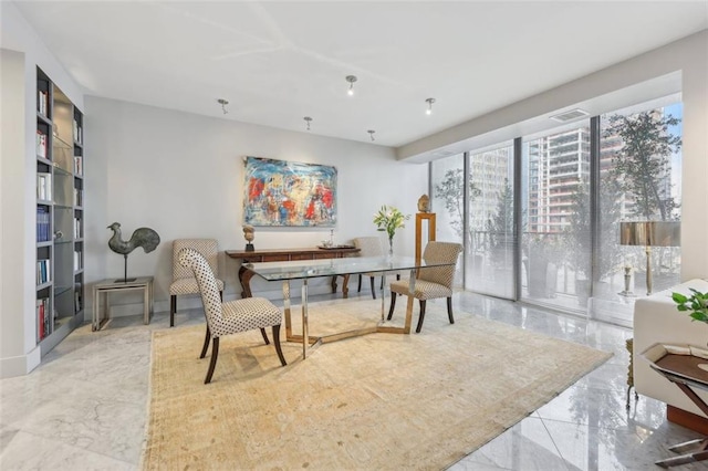 home office with floor to ceiling windows, visible vents, and marble finish floor