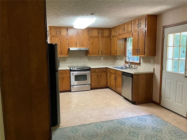 kitchen with appliances with stainless steel finishes, sink, and a textured ceiling