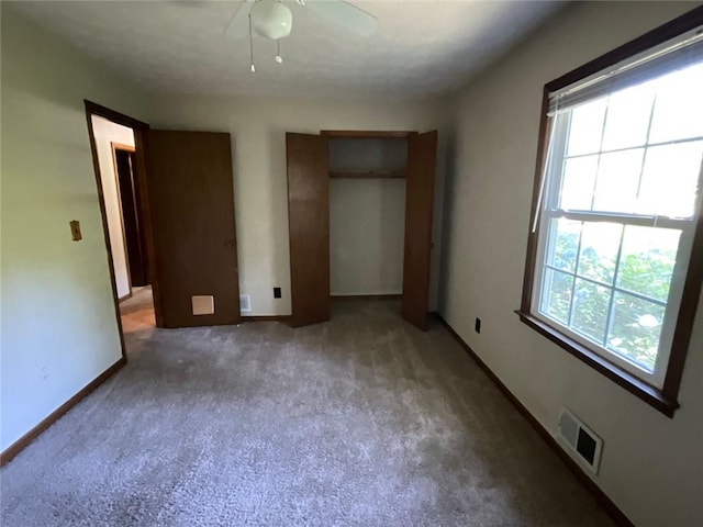 unfurnished bedroom featuring ceiling fan, carpet, and multiple windows