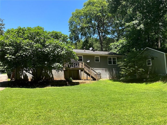 back of house featuring a lawn and a deck