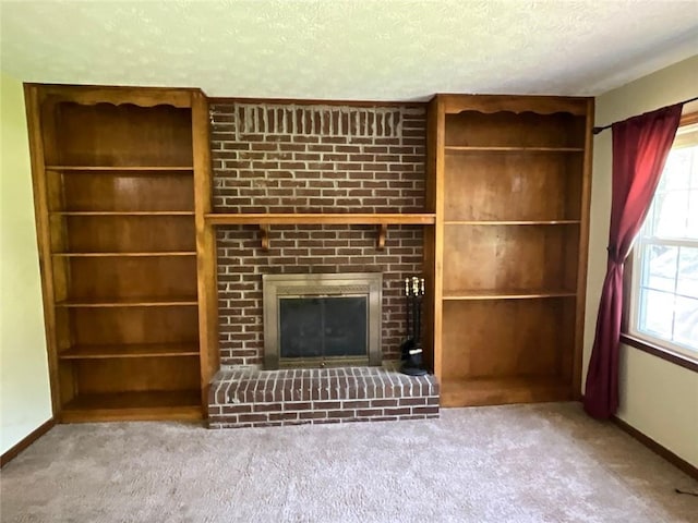 unfurnished living room featuring carpet floors, a textured ceiling, built in features, and a fireplace