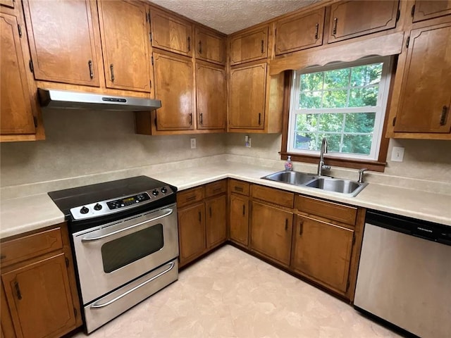 kitchen with sink, a textured ceiling, and stainless steel appliances