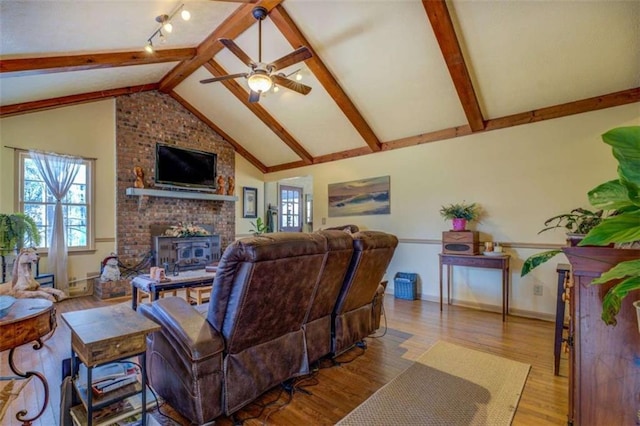 living room featuring a fireplace, lofted ceiling with beams, ceiling fan, and light wood-type flooring