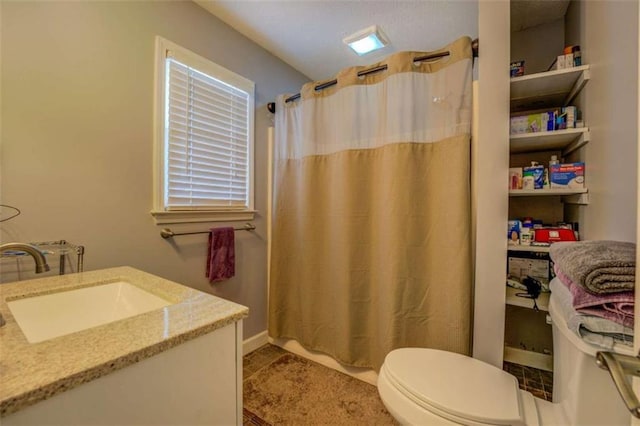 bathroom with vanity, curtained shower, and toilet